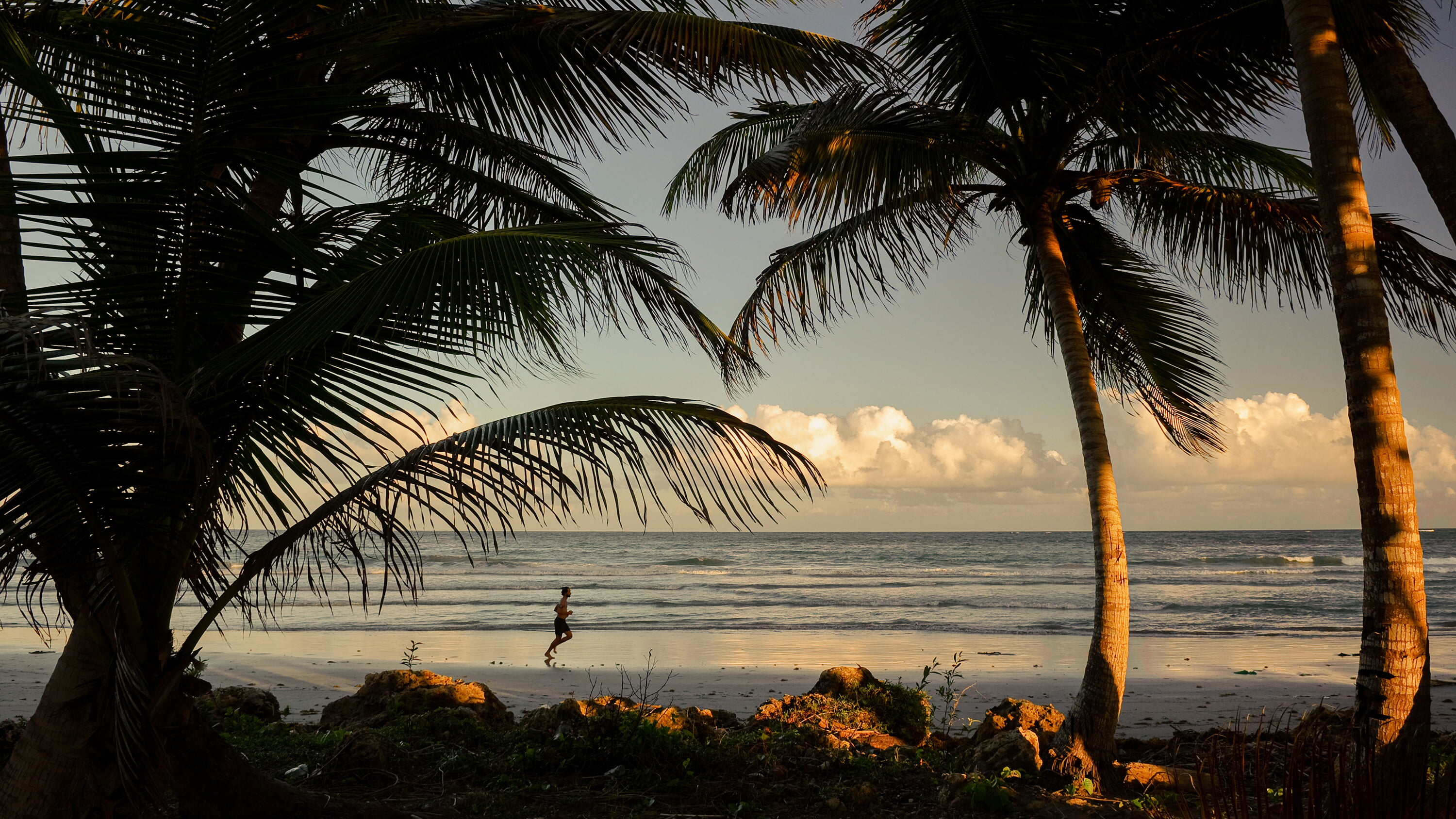 A man running on the beach in Tobago.